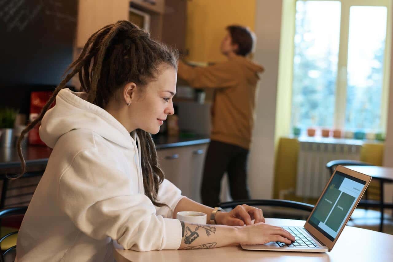 Devojka radi na laptopu kod kuce