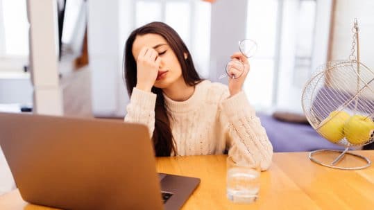 umorna zena sedi ispred laptopa